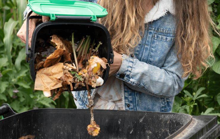 a person putting compost into their bin